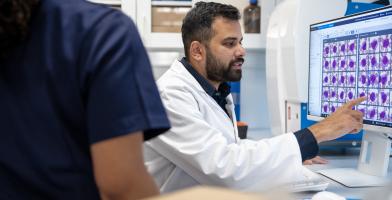 Lab professional reviewing digital cell images on a screen